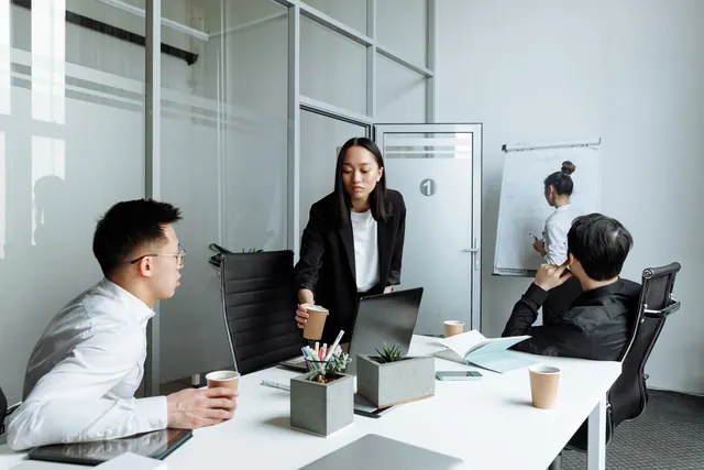 Diverse office team engaged in a collaborative meeting discussing business strategies.