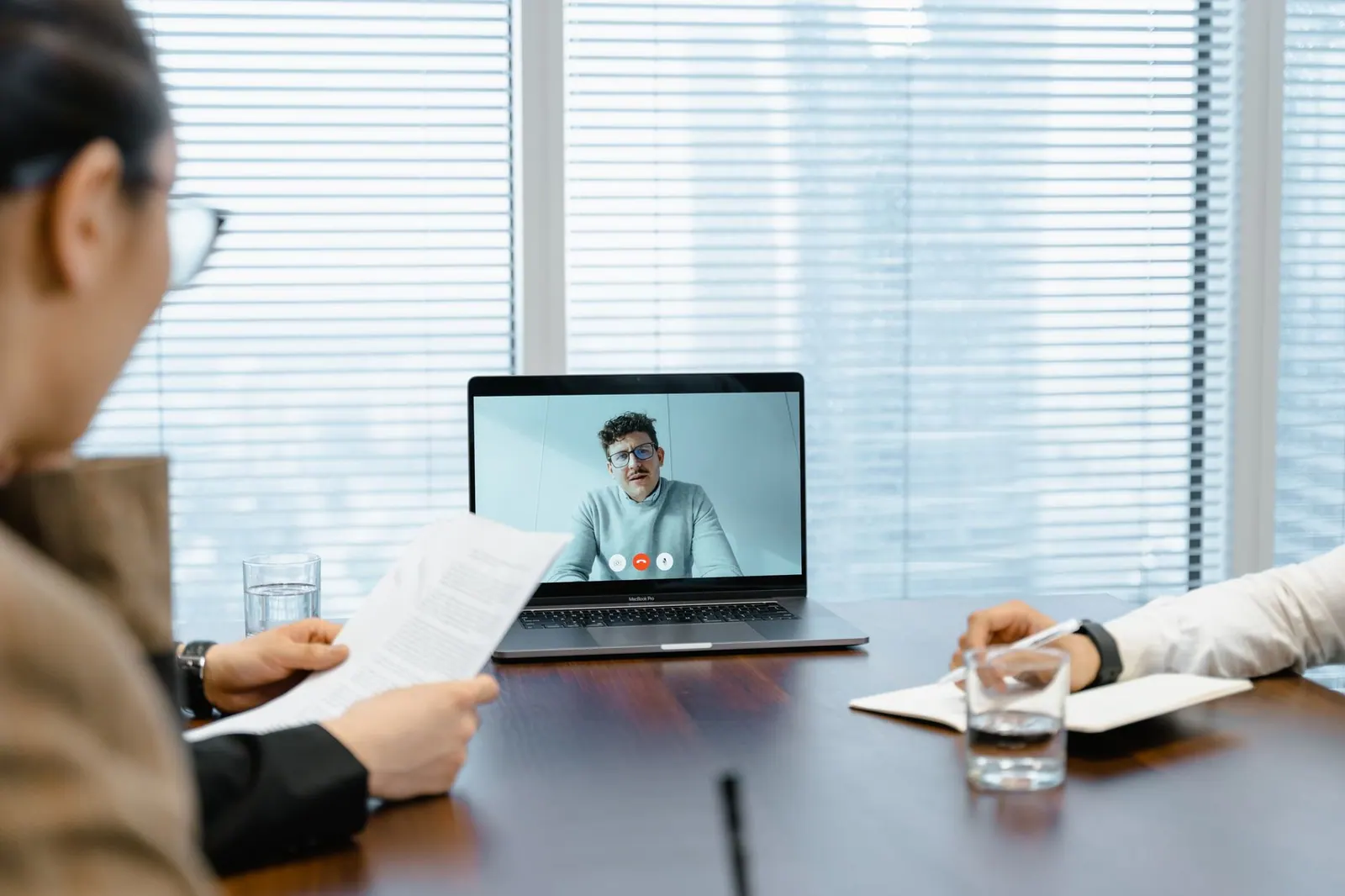 Diverse team in a meeting with remote participant on video call.