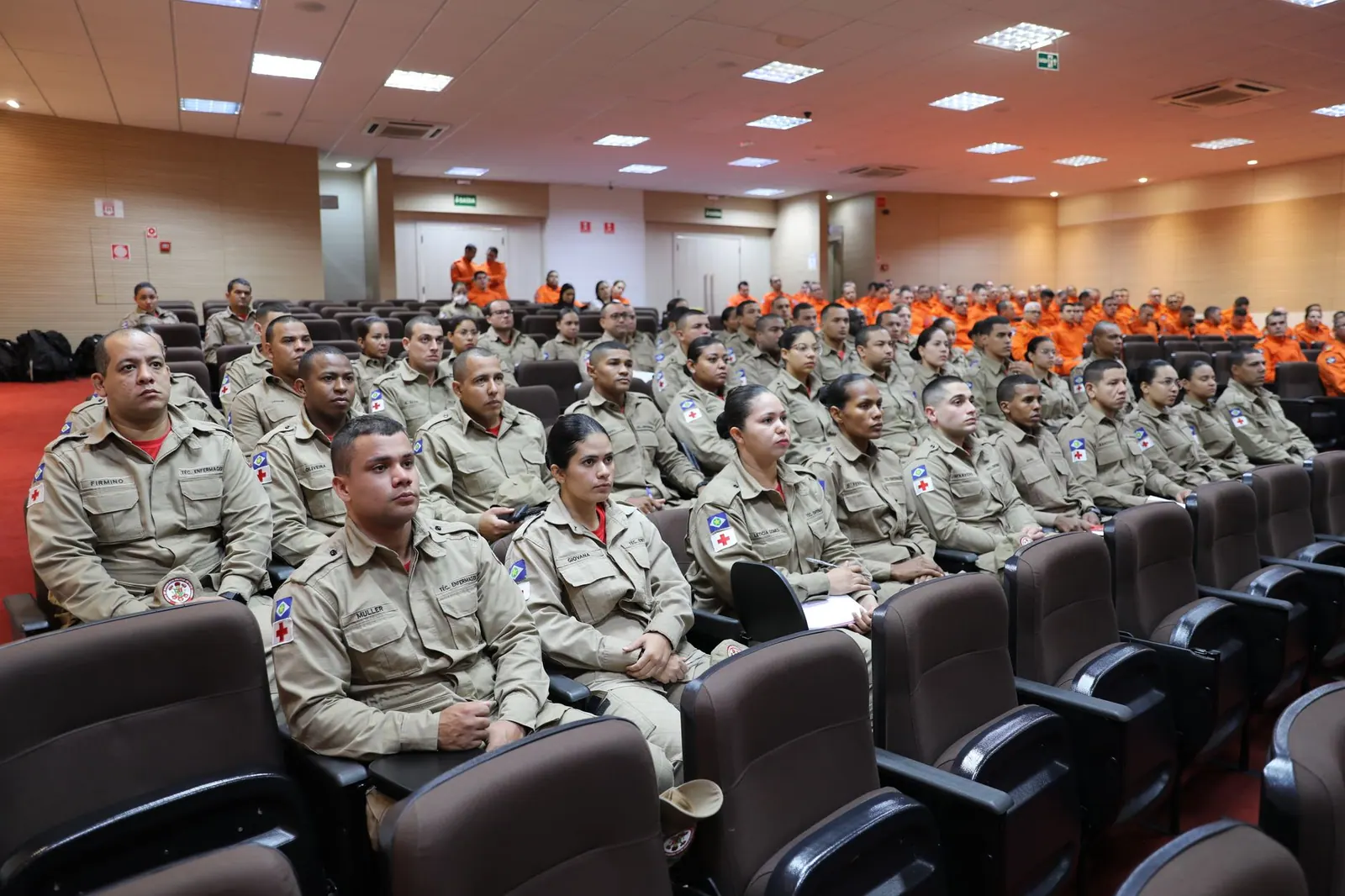 Firefighters in uniform attending a training conference indoors in Mato Grosso, Brasil.