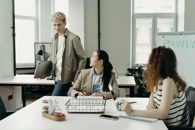 A diverse team of professionals collaborating in a modern office environment, engaged in planning and project development.