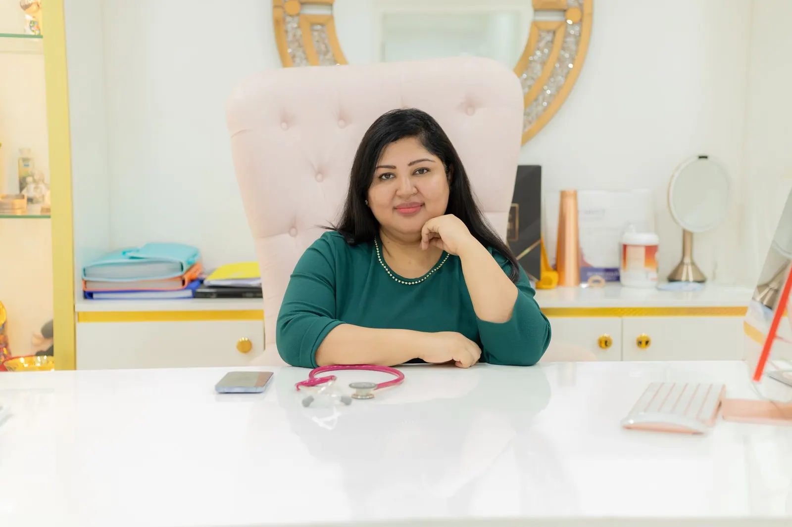 Confident woman seated at desk in a modern office, symbolizing professionalism and elegance.