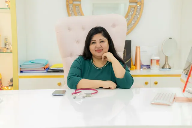 Confident woman seated at desk in a modern office, symbolizing professionalism and elegance.