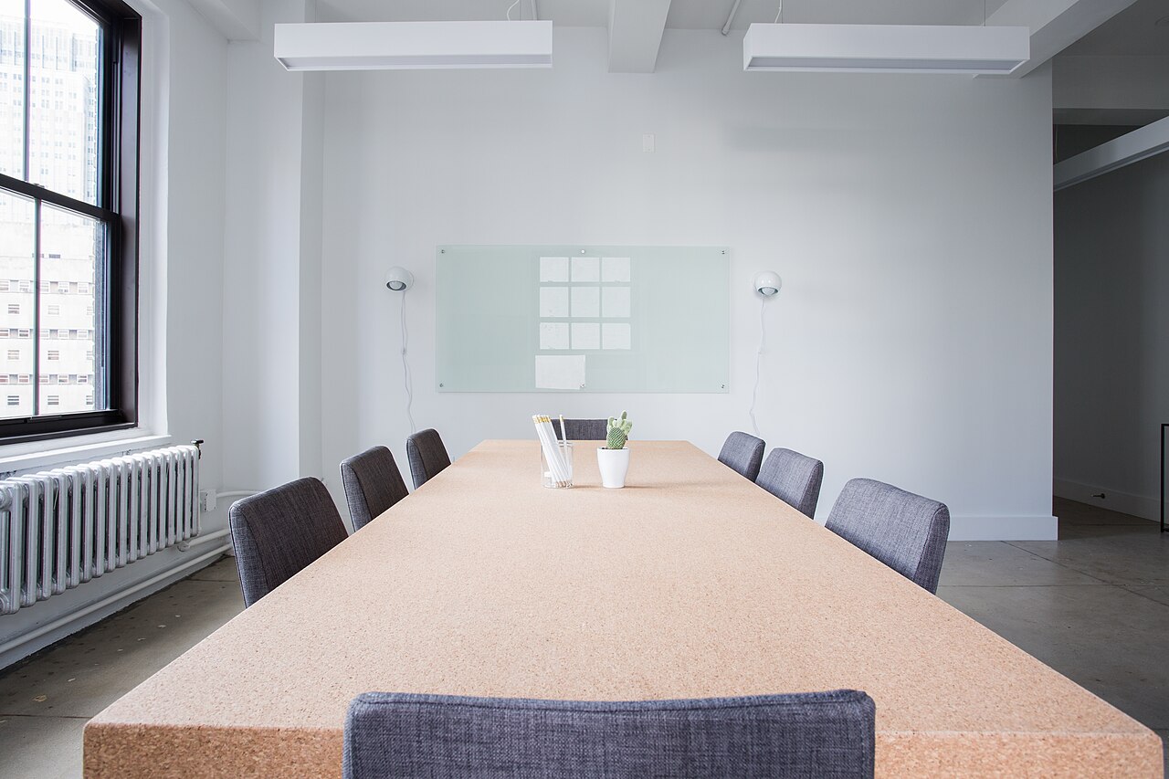 Leerer Besprechungsraum mit Tisch, Stühlen und Fenster