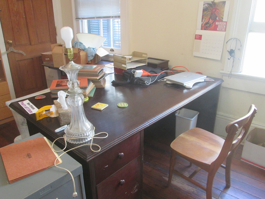 Heimbüro mit dunklem Holzschreibtisch, Stuhl und Büromaterial