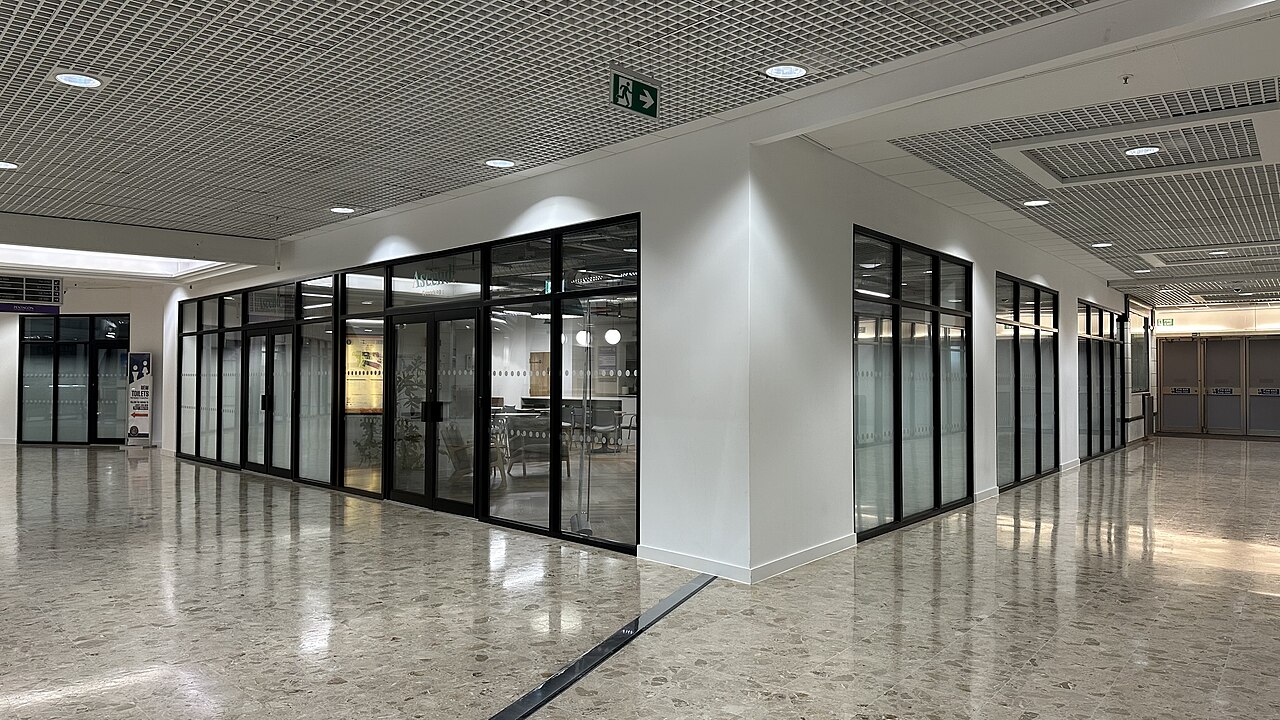 Glasfront eines Coworking-Bereichs mit Tischen und Stühlen
