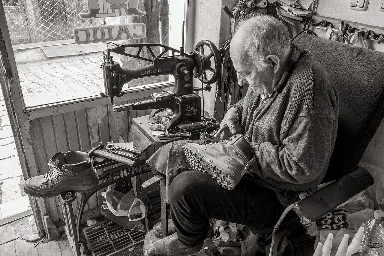 Schuster repariert einen Schuh an seiner Werkbank