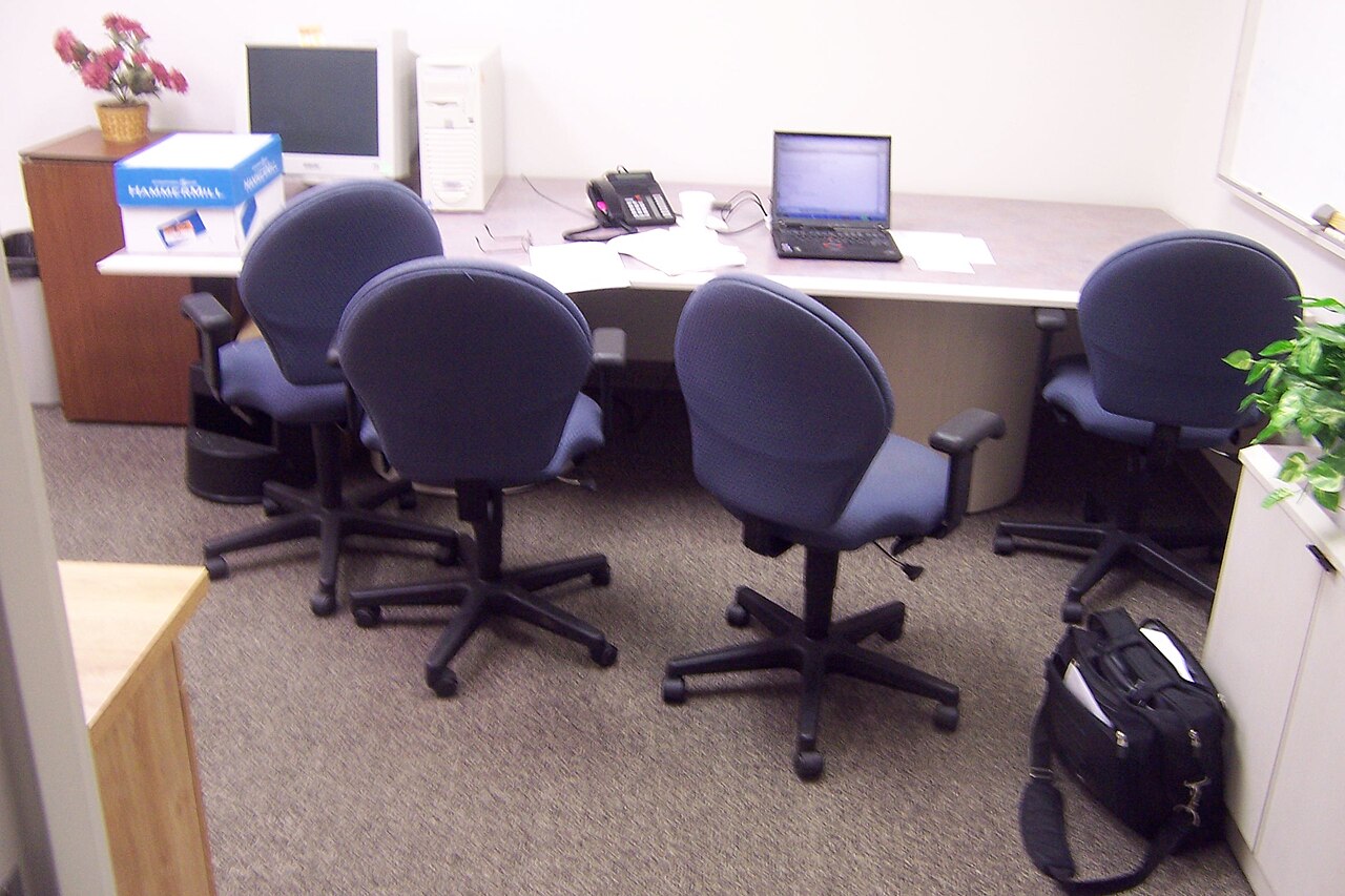 Büroraum mit Schreibtisch, Computer und Bürostühlen