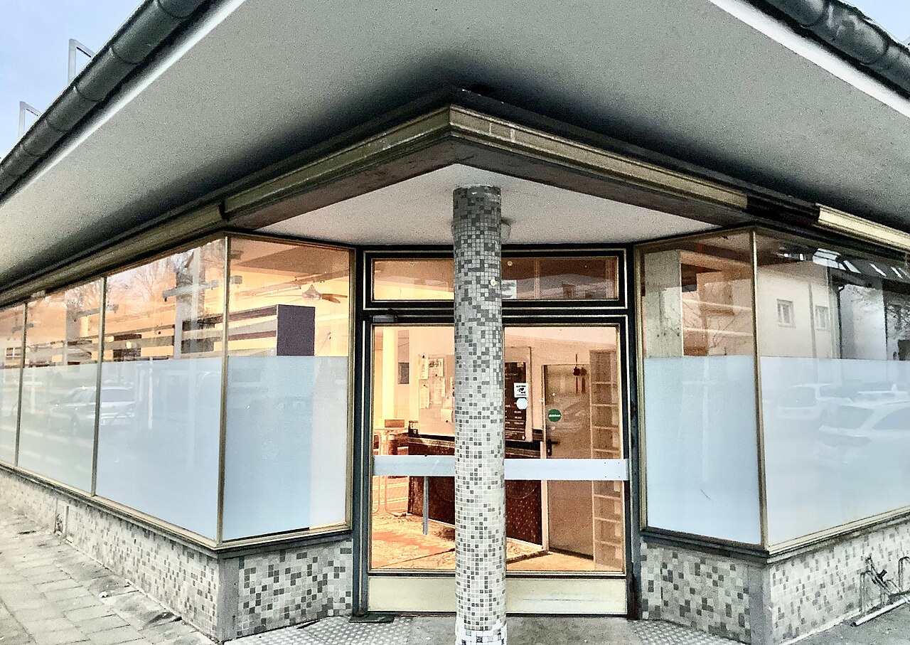 Ehemaliges Ladenlokal mit großen Schaufenstern und mosaikverzierter Säule in Bonn