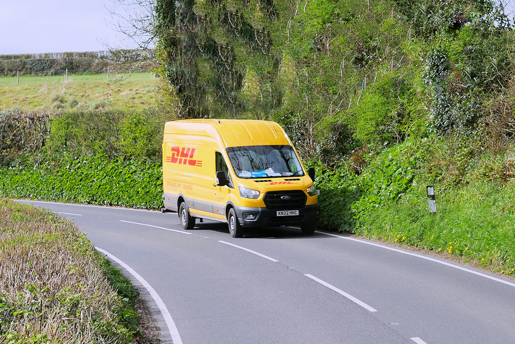 Gelber DHL-Transporter auf einer Landstraße