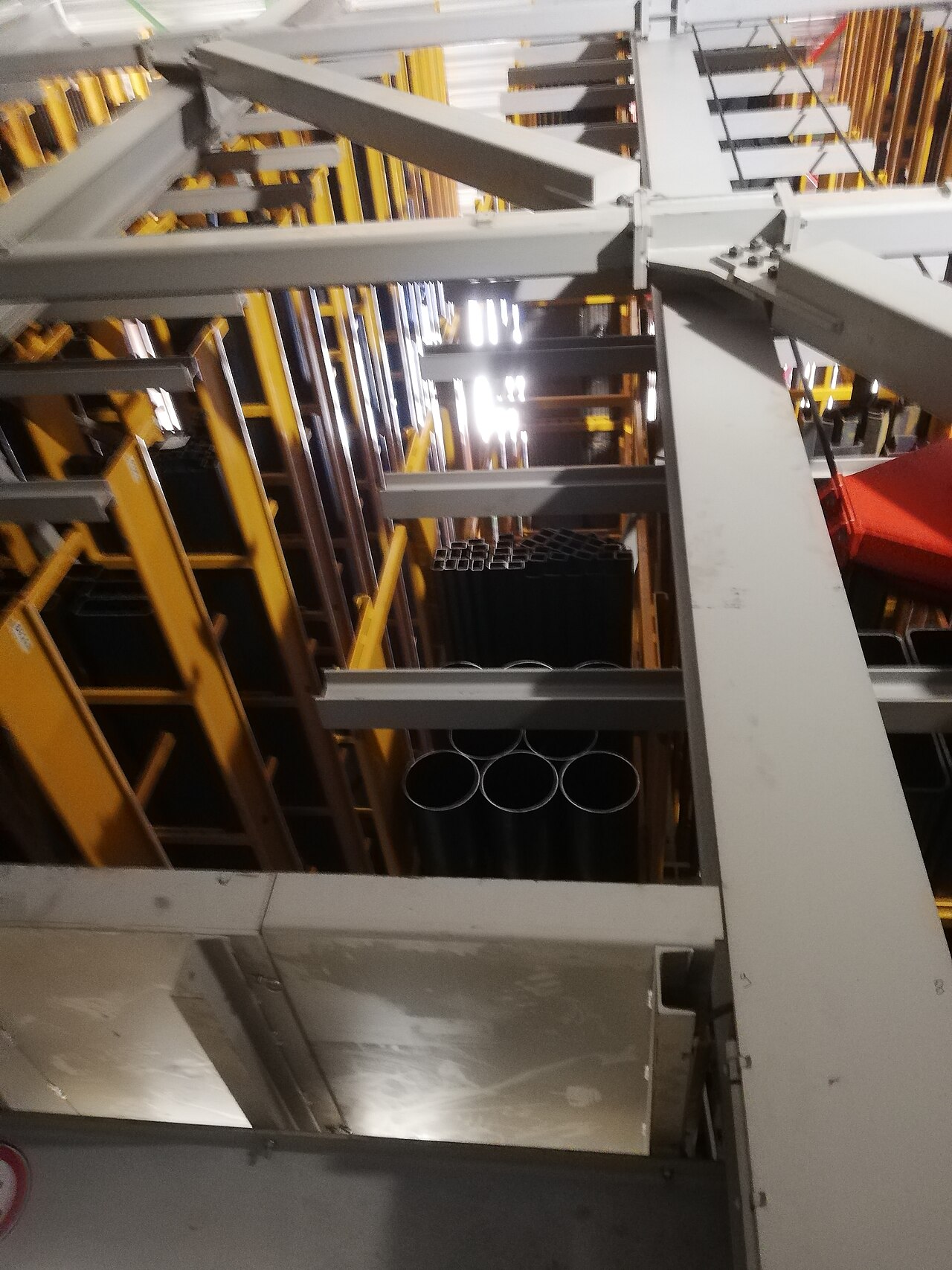 Industrielager mit Stahlregalen und gelagerten Rohren