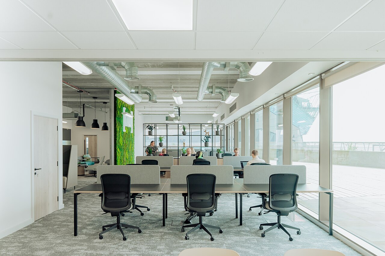 Moderner Coworking-Büroraum mit Sichtbetondecke und Glasfassade