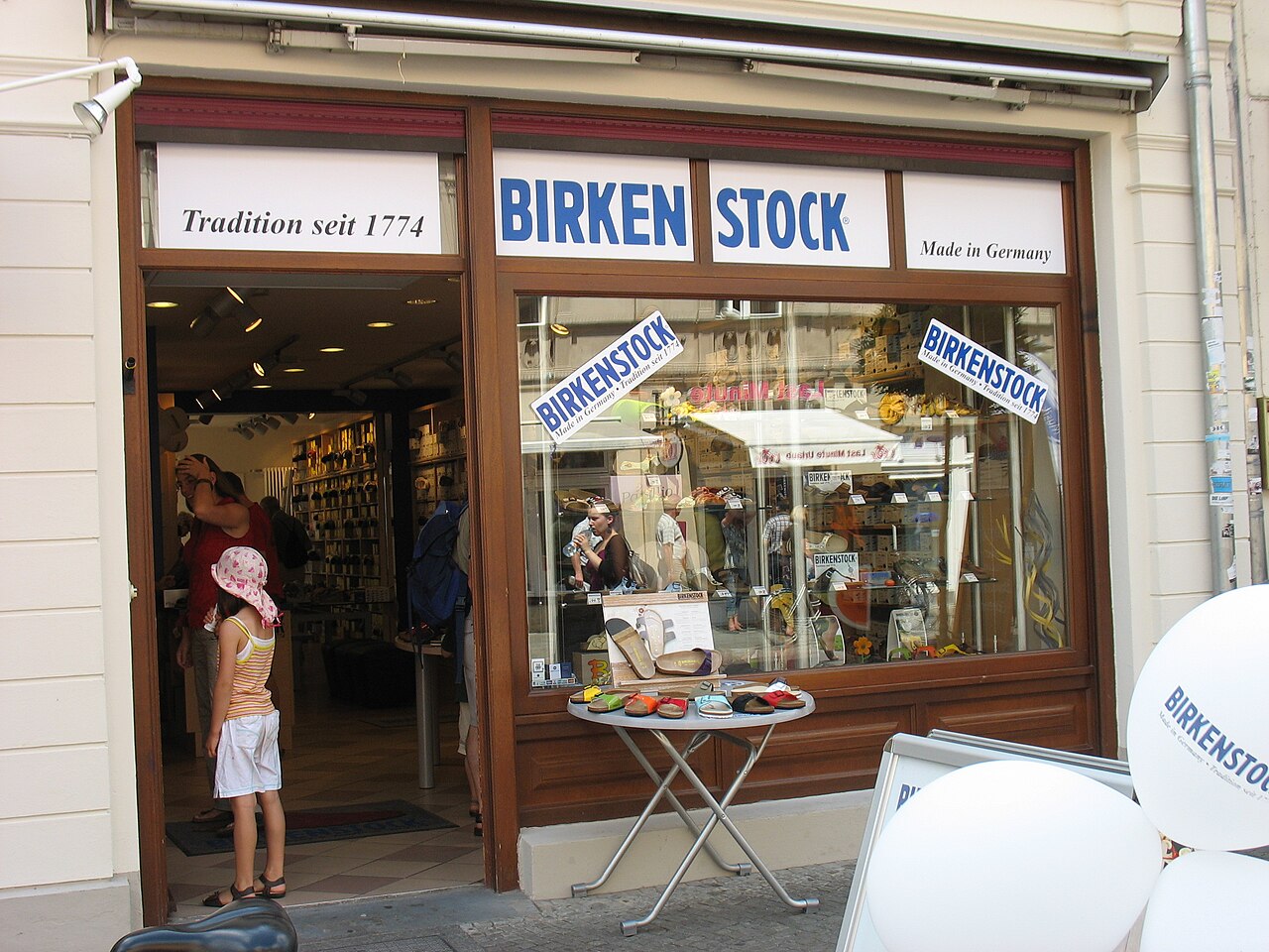 Birkenstock-Laden in Potsdam mit Schaufenster, Tisch mit Sandalen und Kunden im Eingangsbereich