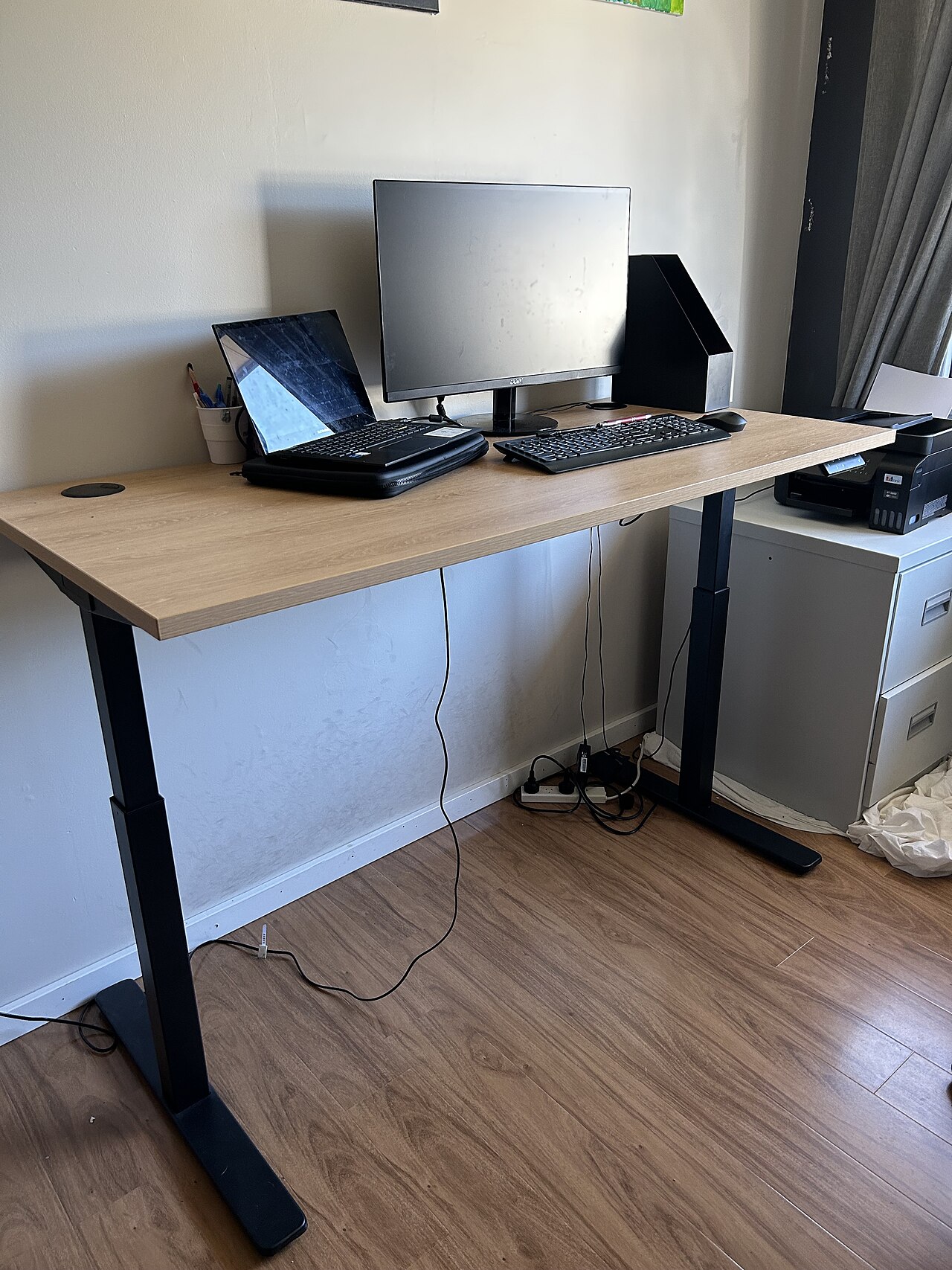 Höhenverstellbarer Schreibtisch mit Computerausstattung in einem Innenraum