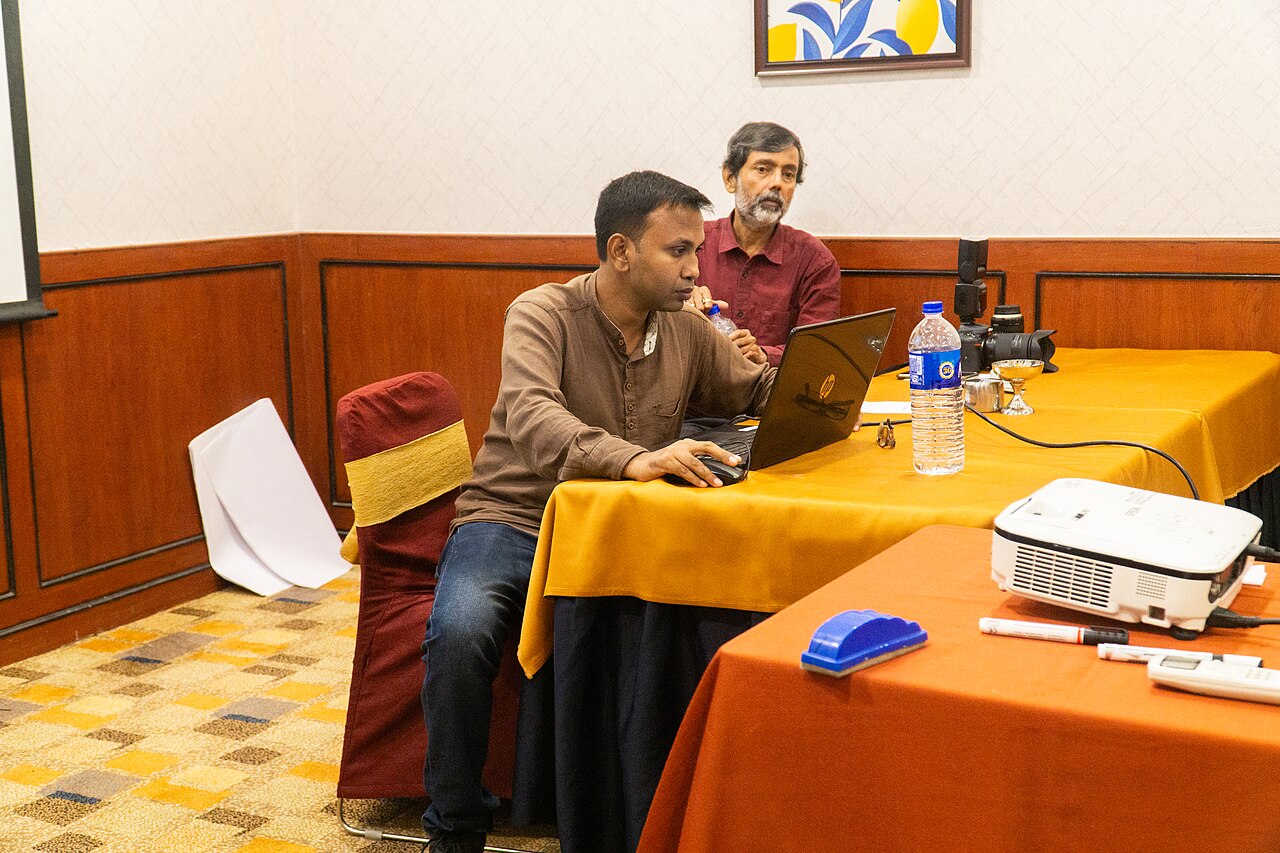 Workshop: Zwei Männer an einem Tisch mit Notebook und Projektor