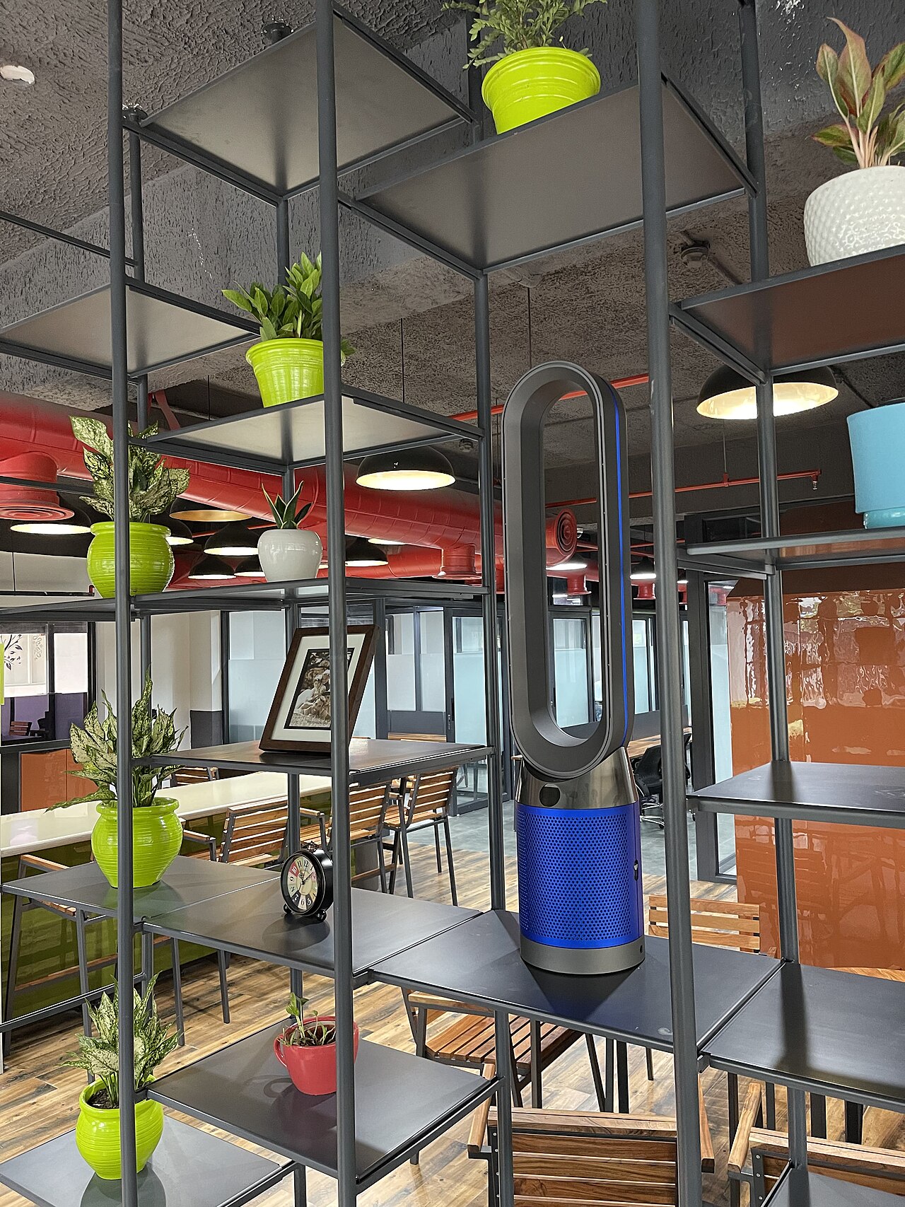 Coworking-Bereich mit Pflanzenregal und Sitzgelegenheiten