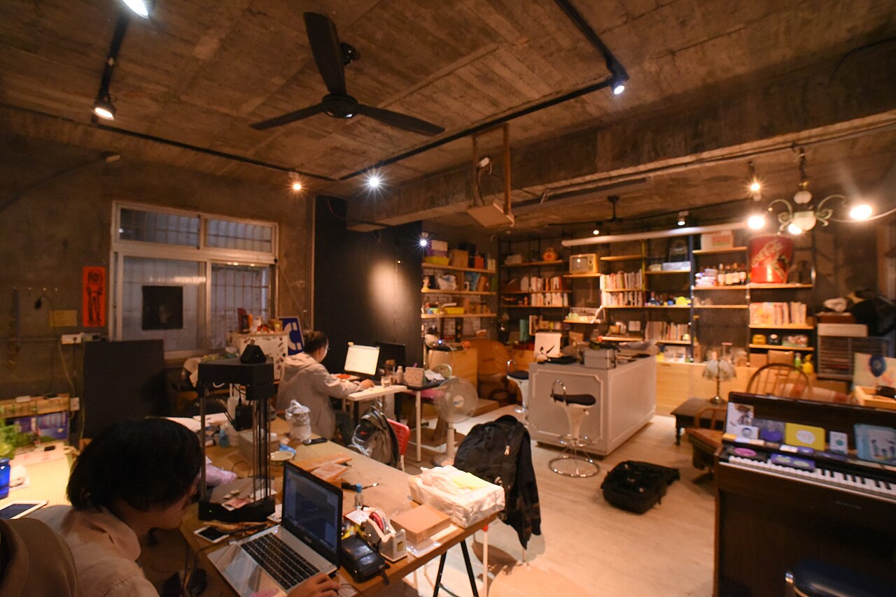 Zwei Personen arbeiten in einem Coworking-Raum an Laptops